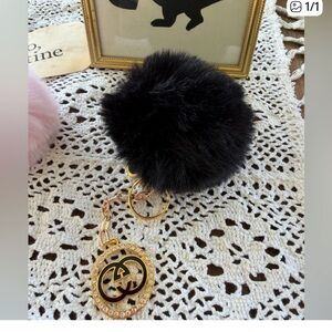Black puffy furry ball with luxury charm with bling. Keychain or bag charm.